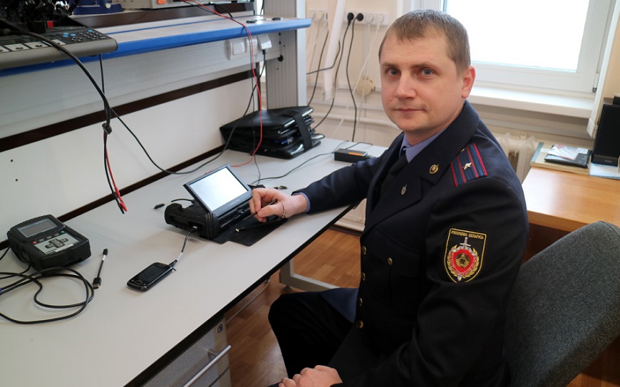 Главный эксперт отдела ГКСЭ Виталий Гузов показывает аппарат для криминалистических исследований для извлечения информации из мобильных устройств
